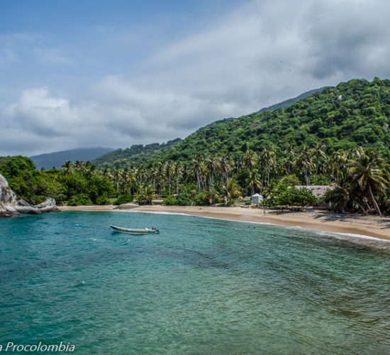 Mar azul con embarcación y montañas al fondo